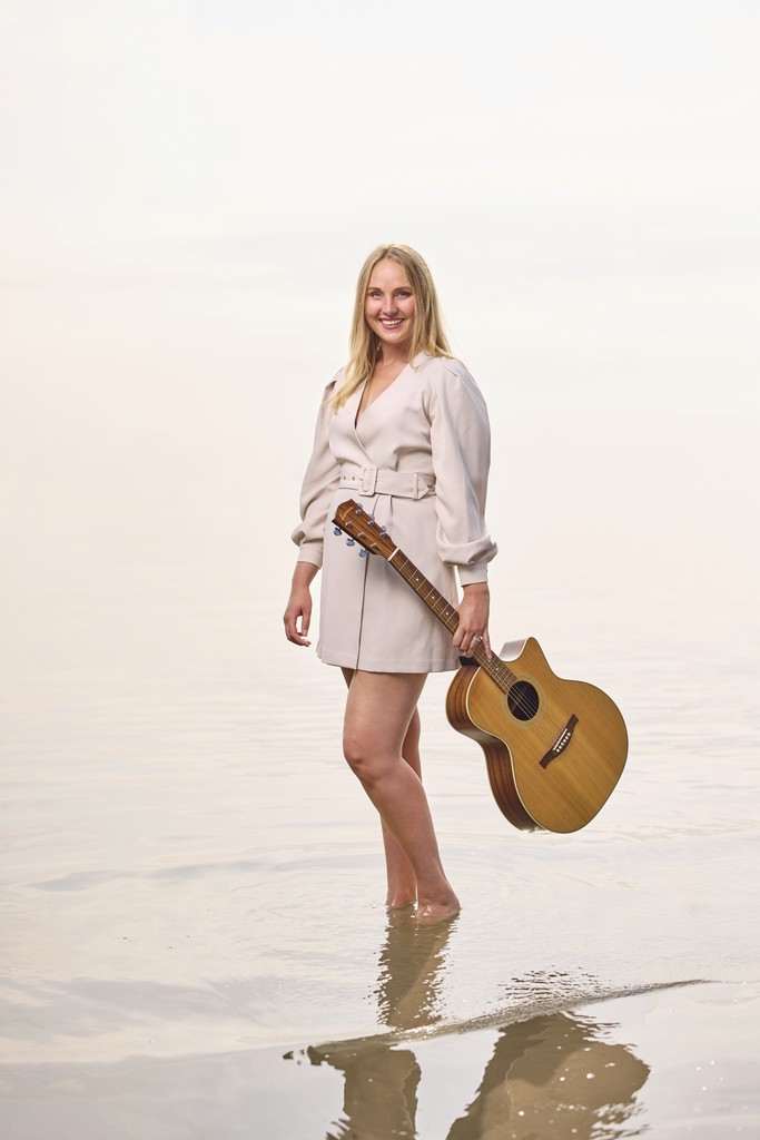 Lisanne Spaander met gitaar aan het water